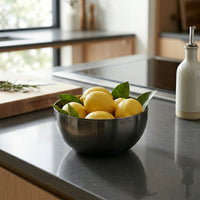 Bowl of lemons on a kitchen counter with a window in the background
