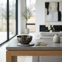 Modern living room with a coffee table featuring a black bowl, keys, and a vase.