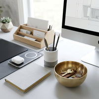 Modern office desk with a computer, notebook, and keys and coins in a small brass bowl