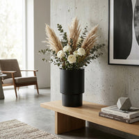 Modern living room with a vase of flowers on a wooden bench.