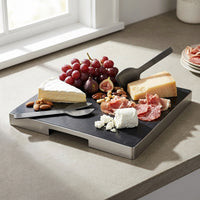 Charcuterie board with cheese, fruits, and meats on a light surface.