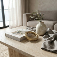 Decorative items on a coffee table in a living room setting with gold paper weight