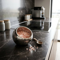 Salt holder with pink salt on a kitchen counter