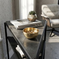 Gold bowl with decorative items on a modern side table in a living room.